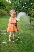 Little girl with garden hose