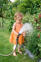 Little girl with garden hose