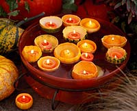 Cucurbita - hollowed pumpkins with candles floating in glass bowl