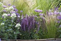 Perennials and grasses in flower bed edging made of hazel rods - wattle