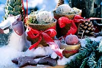 Christmassy arrangement with hoarfrost: pots with coconut fiber, grinding u. kug