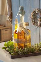 Bottles with herb vinegar and oil tied to wooden coasters
