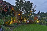 Cottage garden with lighting throughout illuminated at dusk