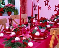 Festive table decorations with poinsettias and balls
