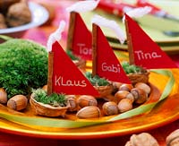 Corylus - hazelnuts, Juglans - walnut shells with moss and sailing as a place card