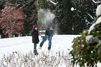 Father and daughter having a snowball fight