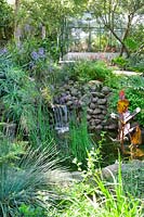 Tropical garden with waterfall and greenhouse