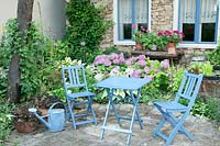 Terrace with blue garden furniture und perennials