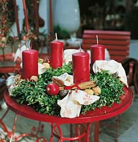 Adventskranz mit roten Kerzen und rustikalem Dekor