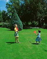Kinder spielen im Park / Rasen