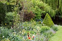 Mill Dene Garden, Blockley, Gloucestershire, Topiary growing in early summer borders