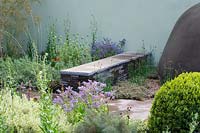 Chelsea Flower Show 2006, London, UK. 'The Saga Insurance garden' ( des. Cleve West ) low stone bench in informal herb garden
