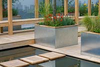 Chelsea Flower Show 2007, 'The Amnesty International Garden' ( Paula Ryan and Artillery Design ) calm reflective pond with wooden 'stepping stones' and metal sided planters