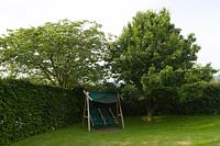 Bourton House Garden, Glos., UK ( Paice ) swing seat beneath trees