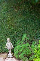 Bickham Park, Devon, UK ( Tremlett ) small statue of girl in front of Box hedge