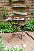 Chelsea Flower Show, 2009. 'Jacob's Ladder' garden ( des. Jeff Hewitt ) simple elegant table and chair in small courtyard garden with brick paving