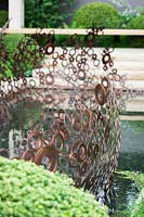 Copper ring sculpture next to pond,The M+G Garden, des. Andy Sturgeon.