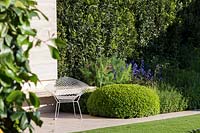 RHS Chelsea Flower Show 2014. The Telegraph Garden, designer Tommaso Del Buono. Elegant metal chair in modern garden. 