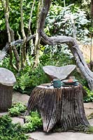 Tree stump table with carved wooden chairs, The Sculptor's Picnic Garden by Walker's Nurseries, RHS Chelsea Flower Show 2015