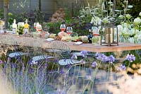 Hampton Court Flower Show 2014, the Vestra Wealth Garden, des. Paul Martin. Modern table and chairs set for a light lunch outdoors