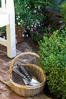 Hampton Court Flower Show 2014, the Hedgehog St Garden, des. Tracy Foster. Trug and gardening tools in small garden