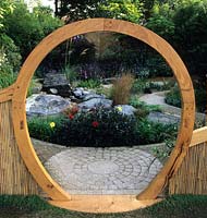 Feng Shui garden London Design Pamela Woods circular moon gate and cobbles curved sinuous cobble path gravel rock garden area