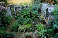 private garden London design Pamela Woods small town suburban patio garden with formal pond covered seat containers trellis mirr