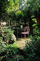 small London town garden Design Jonathan Baillie secluded shady covered eating area with table and chairs