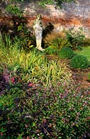 Broxmore Wiltshire Design Pamela Woods autumn border and statue in walled garden Ceratostigma willmottiana