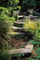 Brownshill Gloucestershire design Pamela Woods railway sleepers and mulch filled step in steeply sloping garden seating area
