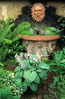 large Whichford terracotta container as water feature with sun face plaque Mind your own business and pebbes small walled shade