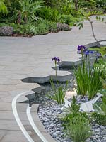The Manchester Garden. The hexagonal and rectacular  paving adds interest to the water feature and contrast well with the gravel in the water feature.  - Designer: Exterior Architecture. RHS Chelsea Flower Show 2019