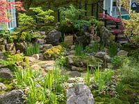 The Green Switch garden. The large shallow water feature with moss covered rocks planted with Blue Iris and surrounded by Acer Palmatum and Bonsai trees. Design:  Kazuyuki Ishihara. Sponsor: G-Lion