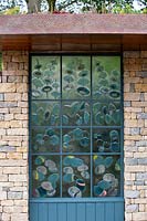 The Warners Distillery Garden, hand crafted glass panel with blue tint created from copper reacting with the glass, inspired by the distillation process, designed by Wendy Newhofer - Design: Helen Elks-Smith - Construction: Bowles and Wyer - Sponsor: Warners Gin. 