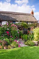 Thatched cottage with dahlias, annuals and perennials, Hilltop garden, July.