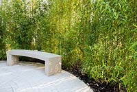 Stone curved bench with bamboos screening - Phyllostachys aurea 'fish-pole bamboo' AGM. Perennial Sanctuary Garden. RHS Hampton Court Palace 2017.