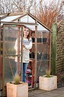 Opening a greenhouse door for ventilation in winter