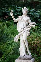 Statue of Demeter - Ceres  - on The Promenade of The Gods surrounded by  Chamaerops Humilis and Monstera deliciosa - Swiss Cheese Plant. Sintra, Portugal.