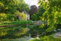 View across river coln to french style gazebo, summer house - Ablington manor, gloucestershire
