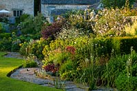 Curving herbaceous border by the lawn - Ablington Manor, Gloucestershire