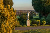 A view of a white statue among evergreen hedging at Brodsworth Hall, Yorkshire. 