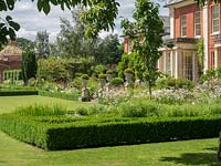 Formal garden featuring Buxus sempervirens hedging and topiary balls planted in urns at Newport House, Herefordshire.
