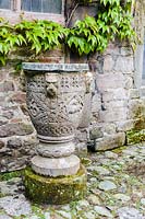 A carved font decorated with animals, in the courtyard at Askham Hall, near Penrith, Cumbria, UK. 