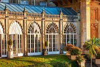 Orangery at Sezincote, Gloucestershire, with containers of fuchsias outside in morning light. 