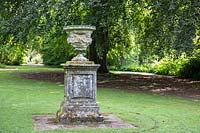 A stone pillar and urn with antique carving on lawn at Newby Hall and Gardens, Yorkshire. 