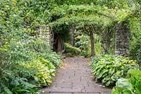 A view of a flagstone paved garden and archway at Newby Hall and Gardens, Yorkshire.  