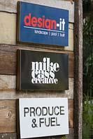 Three advertising signs on timber wall, Australia