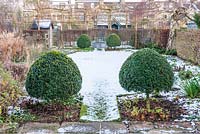 Formal walled town garden with snow and Box topiary