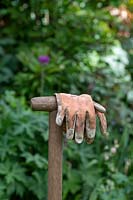 Gardening gloves on an old wooden fork handle