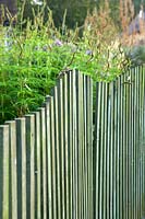 A view of a wavy wooden fence. 